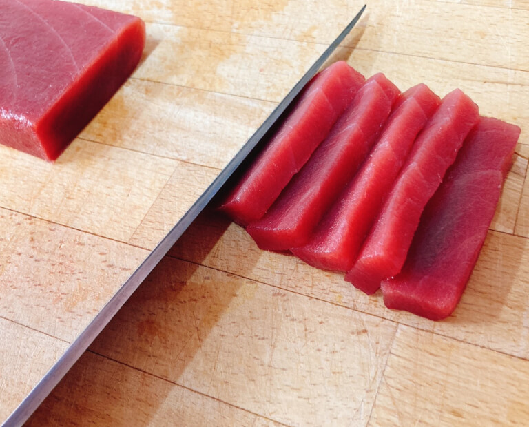 切られたまぐろの柵がまな板に綺麗に並んでいる